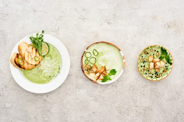 Flat lay with delicious creamy green soup served with croutons — Stock Photo