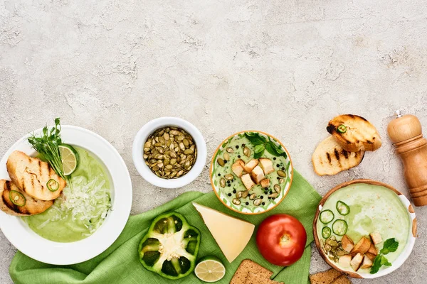 Vista superior de deliciosa sopa verde cremosa servida com legumes e croutons em guardanapo verde — Fotografia de Stock