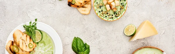 Панорамный снимок вкусного сливочно-зеленого овощного супа, подаваемого с зеленью и гренками — стоковое фото