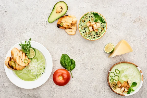 Vista superior de la deliciosa sopa de verduras verde cremosa servida con vegetación y crutones - foto de stock