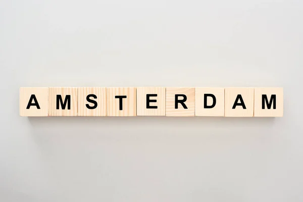 Top view of wooden blocks with Amsterdam lettering on grey background — Stock Photo