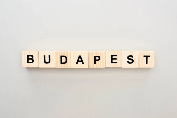 Top view of wooden blocks with Budapest lettering on grey background — Stock Photo