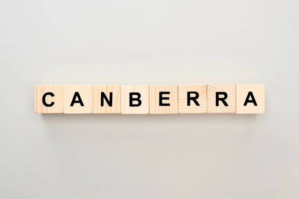 Vista superior de bloques de madera con letras Canberra sobre fondo gris - foto de stock