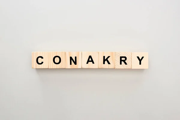 Top view of wooden blocks with Conakry lettering on grey background — Stock Photo