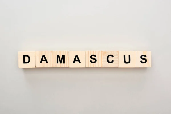 Top view of wooden blocks with Damascus lettering on grey background — Stock Photo