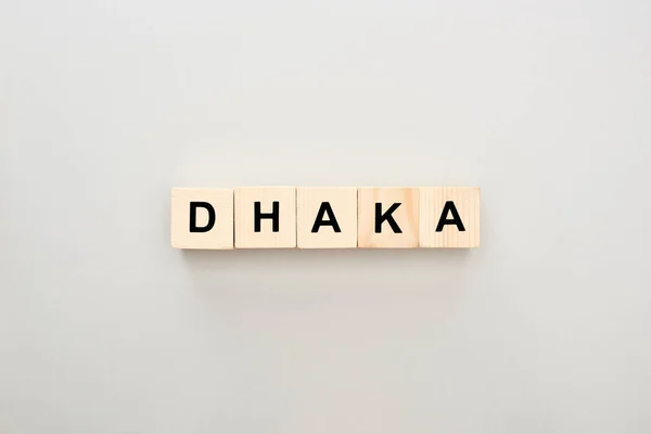 Top view of wooden blocks with Dhaka lettering on grey background — Stock Photo