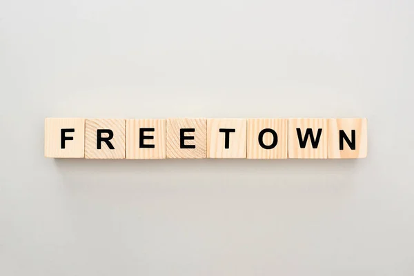 Top view of wooden blocks with Freetown lettering on grey background — Stock Photo