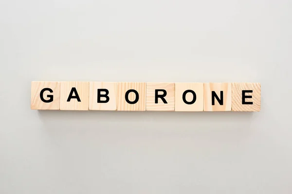 Vue de dessus des blocs de bois avec lettrage Gaborone sur fond gris — Photo de stock