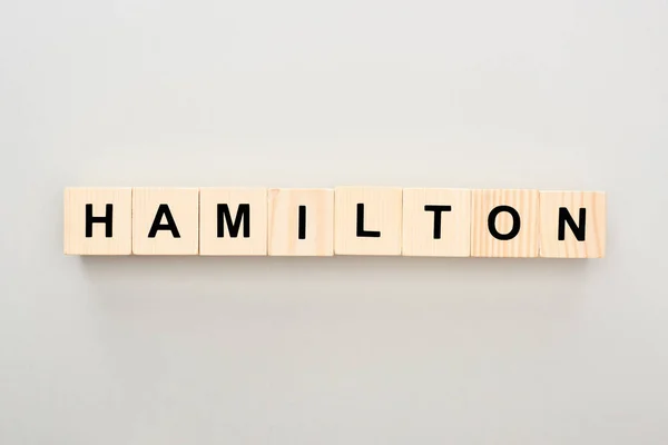 Vista dall'alto di blocchi di legno con scritte Hamilton su sfondo grigio — Stock Photo