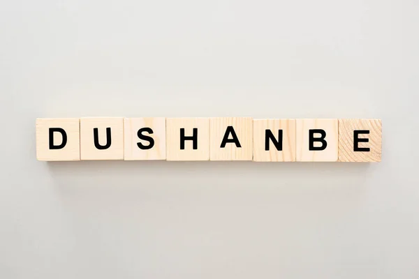 Top view of wooden blocks with Dushanbe lettering on grey background — Stock Photo