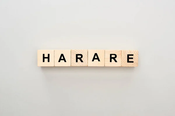 Vista superior de bloques de madera con letras Harare sobre fondo gris - foto de stock