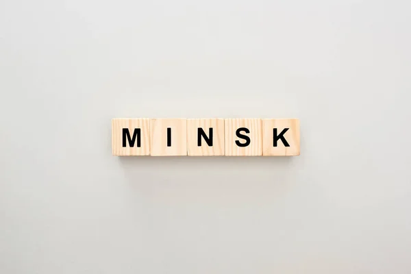 Vista superior de bloques de madera con letras de Minsk sobre fondo gris - foto de stock