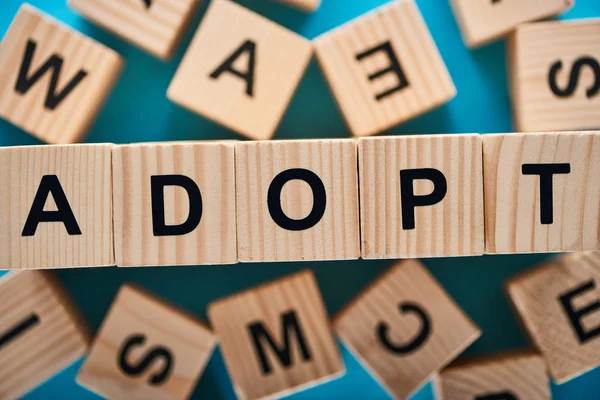 Selective focus of adopt word made of wooden cubes — Stock Photo