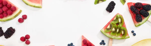 Tiro panorâmico de deliciosa melancia em paus com bagas e kiwi no fundo branco — Fotografia de Stock