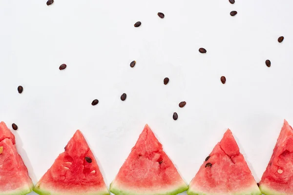 Fila de deliciosas rebanadas jugosas de sandía sobre fondo blanco - foto de stock