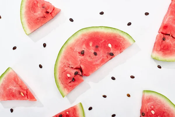 Vista superior de deliciosas rebanadas jugosas de sandía con semillas sobre fondo blanco - foto de stock