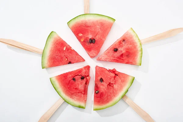 Top view of delicious watermelon slices on wooden sticks on white background — Stock Photo