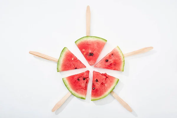 Draufsicht auf köstliche saftige Wassermelonenscheiben auf Holzstäben auf weißem Hintergrund — Stockfoto