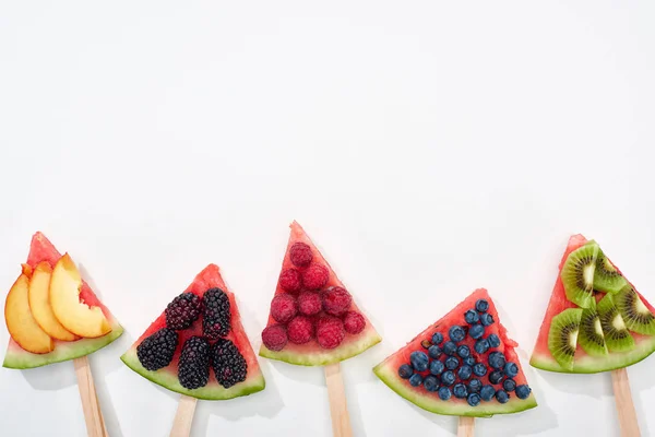 Top view of fresh watermelon on sticks with seasonal berries and fruits on white background with copy space — Stock Photo