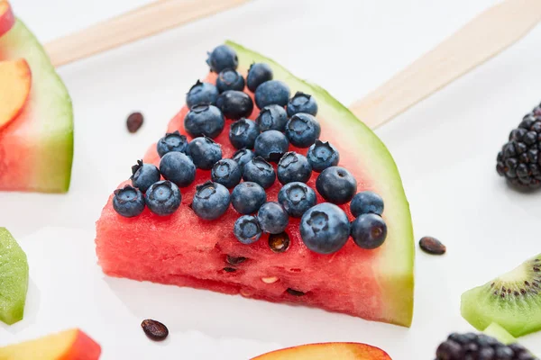 Close up view of delicious dessert with watermelon on stick and blueberries on white background — Stock Photo