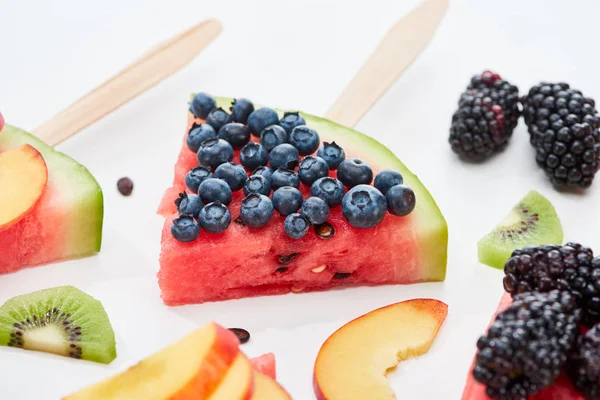 Delicioso postre con sandía en palo y arándanos sobre fondo blanco - foto de stock