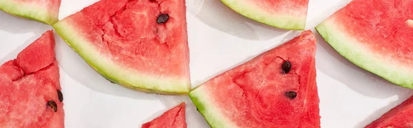 Panoramic shot of delicious fresh watermelon slices in rows on white background — Stock Photo