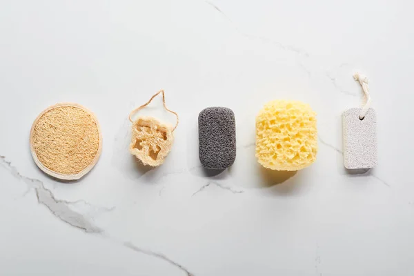 Top view of bath sponges and pumice stones on marble surface — Stock Photo