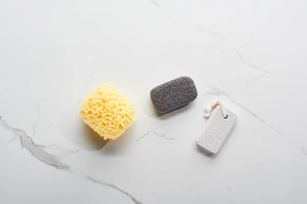 Top view of bath sponge and pumice stones on marble surface — Stock Photo