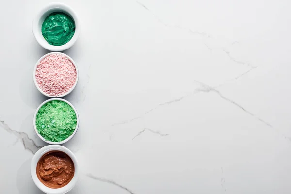 Vue de dessus des sels de bain de couleur et masque naturel sur la surface de marbre — Photo de stock