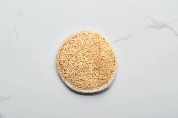Vista superior de la esponja natural de la cara en la superficie de mármol - foto de stock