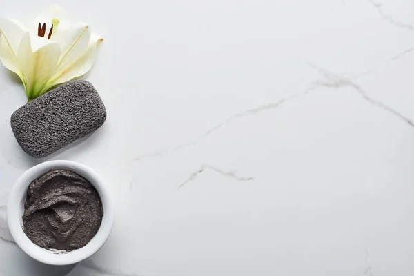 Top view of natural clay mask and pumice stone near fresh flower on marble surface — Stock Photo