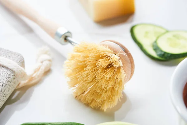 Close up view of body brush near cucumber slices on white surface — Stock Photo