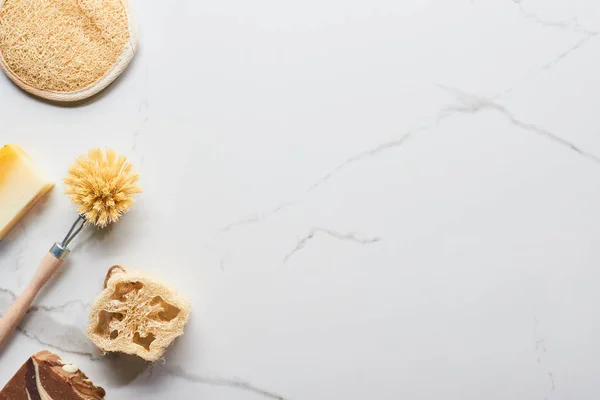 Vista superior da esponja de banho, sabão loofah e escova de corpo na superfície de mármore — Fotografia de Stock