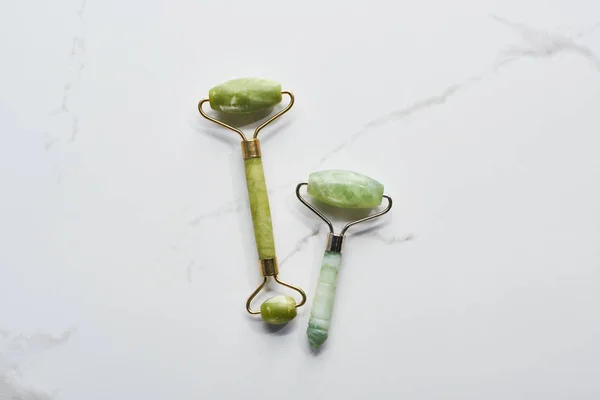 Top view of nephrite massage rollers on marble surface — Stock Photo