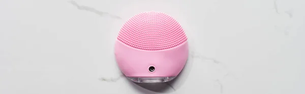Tiro panorâmico de silicone rosa limpeza escova facial na superfície de mármore — Fotografia de Stock