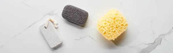 Colpo panoramico di pietra pomice grigio chiaro e scuro e spugna da bagno sulla superficie di marmo — Foto stock
