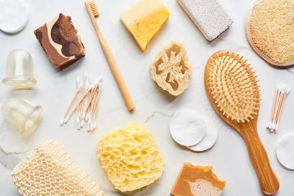 Vue de dessus des accessoires de salle de bain, bocaux de massage et morceaux de savon sur la surface de marbre — Photo de stock