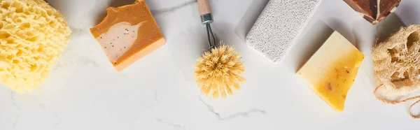 Panoramic shot of bath sponge, pumice stone, body brush, soap on marble surface — Stock Photo