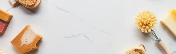 Панорамний знімок щіток тіла та натуральних шматочків мила на мармуровій поверхні — стокове фото
