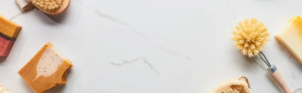 Panoramic shot of body brushes and natural soap pieces on marble surface — Stock Photo