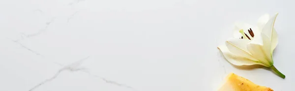 Panoramaaufnahme frischer weißer Blüten in der Nähe natürlicher Seifenstücke auf Marmoroberfläche — Stockfoto