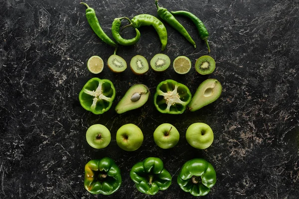 Vue de dessus des pommes fraîches, avocats, kiwi, citrons verts, poivrons et courgettes — Photo de stock