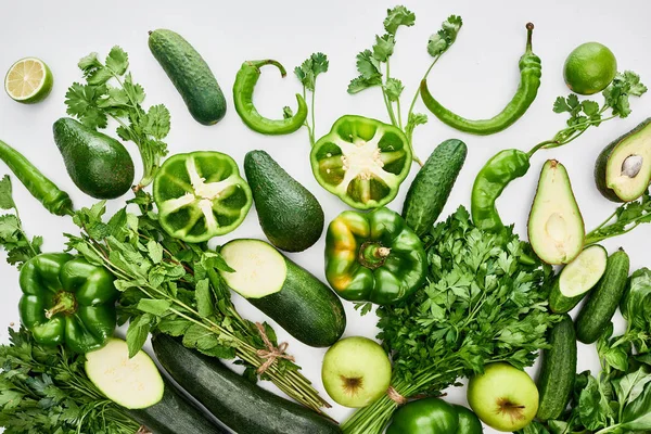 Vista superior de manzanas, aguacates, pepinos, limas, pimientos, vegetación y calabacín - foto de stock