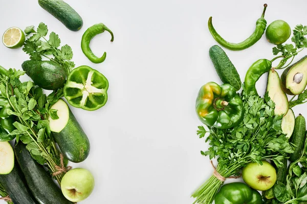 Top view of apples, avocados, cucumbers, limes, peppers, greenery and zucchini — Stock Photo