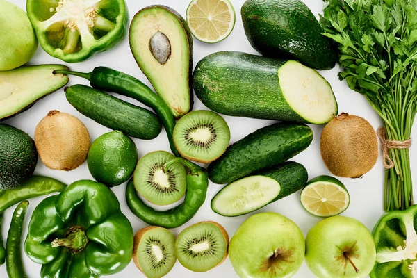 Vista superior de maçãs, abacates, pepinos, limas, pimentas, kiwi, vegetação e abobrinha — Fotografia de Stock