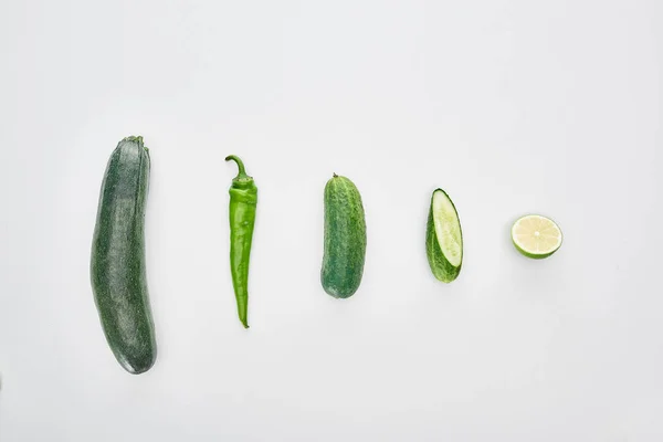 Top view of fresh and green cucumbers, lime, pepper and zucchini — Stock Photo