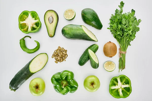 Top view of apples, avocados, cucumbers, limes, peppers, kiwi, pumpkin seeds, greenery and zucchini — Stock Photo