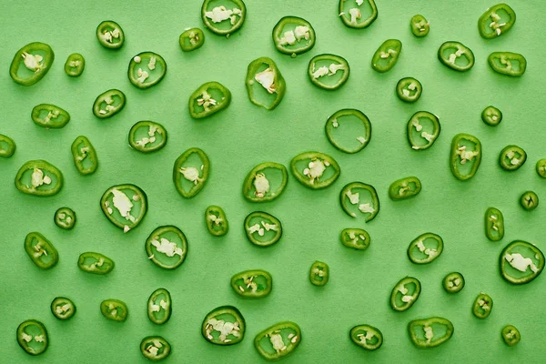Top view of sliced and fresh peppers on green background — Stock Photo