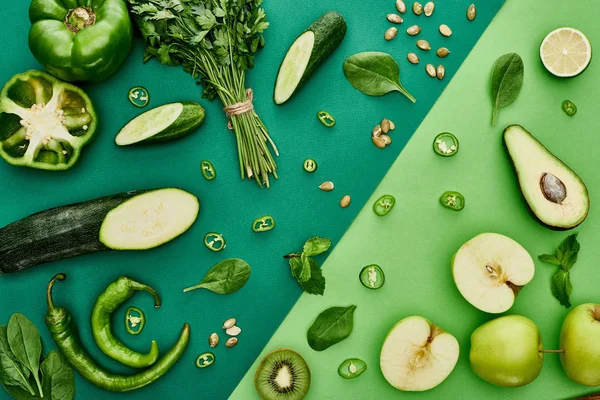 Vue de dessus des pommes, avocat, concombres, citron vert, poivrons, kiwi, verdure, graines de citrouille et courgettes — Photo de stock