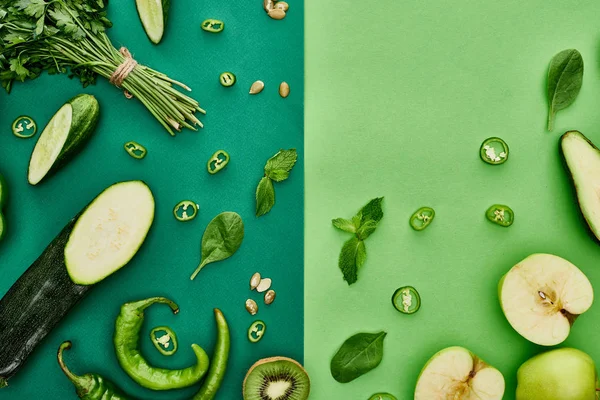 Top view of apples, avocado, cucumbers, peppers, kiwi, greenery, pumpkin seeds and zucchini — Stock Photo